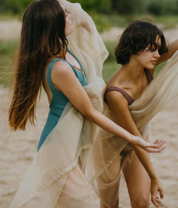Woman in a graceful flowing movement pose with cyan accents.